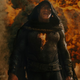 Black Adam in a hood with fire around him